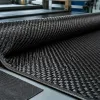 Heavy 12K carbon fiber fabric roll beside a finer weave sample